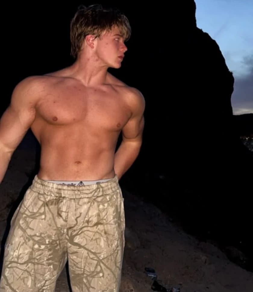 Eric English shirtless at dusk, looking over his shoulder